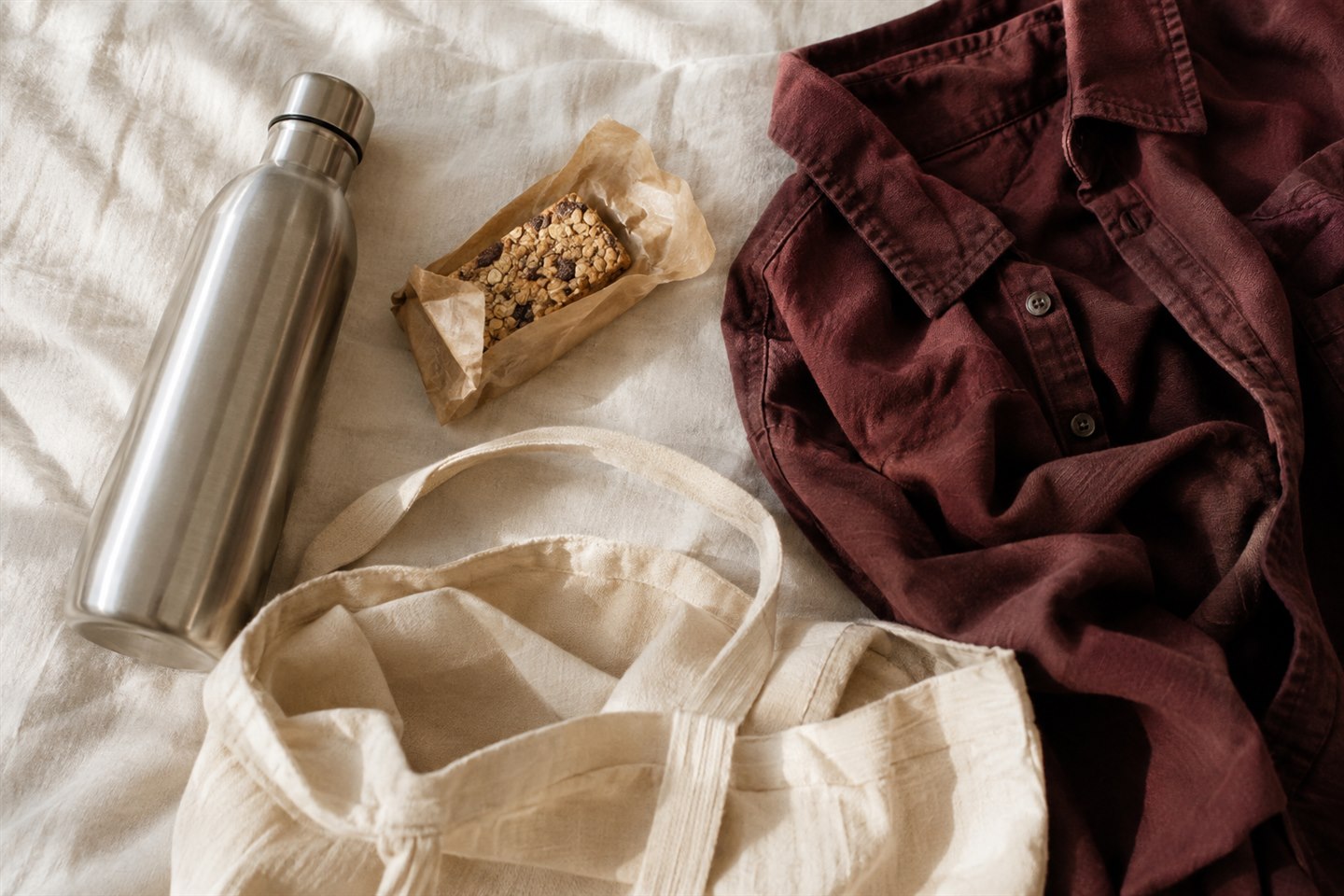 A reusable water bottle, familiar snack, loose shirt, and canvas bag ready for an appointment.